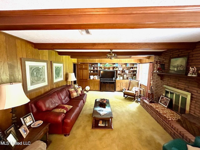 carpeted living room featuring beam ceiling, wood walls, and a brick fireplace