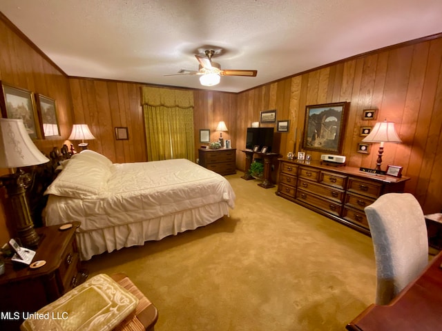 carpeted bedroom with a textured ceiling, ornamental molding, wooden walls, and ceiling fan