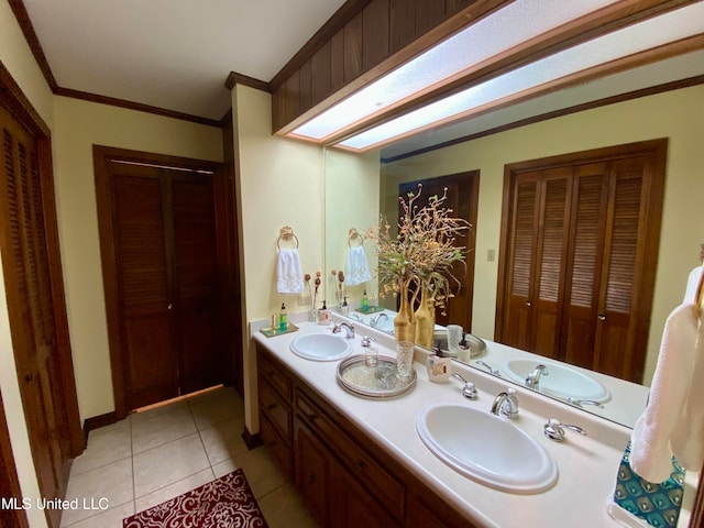 bathroom with vanity, crown molding, tile patterned floors, and a skylight