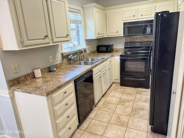 kitchen with sink, light tile patterned floors, black appliances, and cream cabinetry