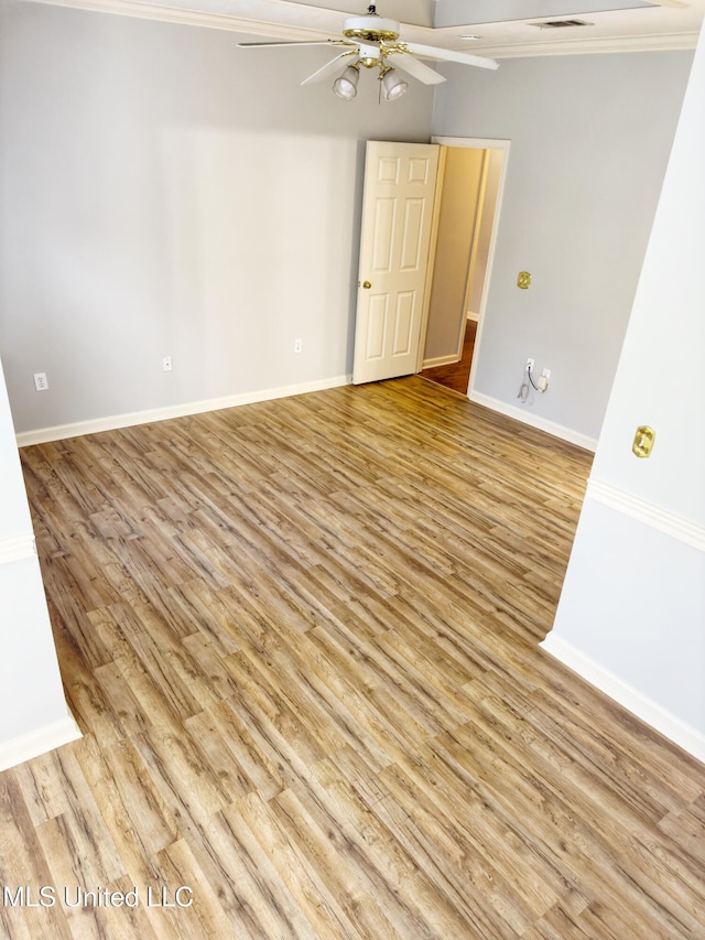 empty room featuring light wood-type flooring, ceiling fan, and crown molding