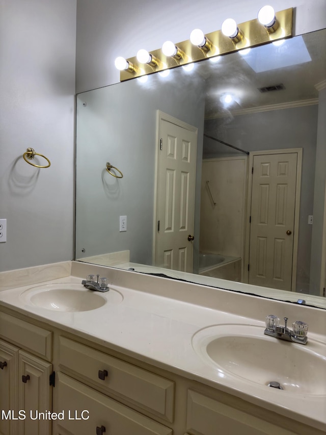 bathroom with vanity, crown molding, and a skylight