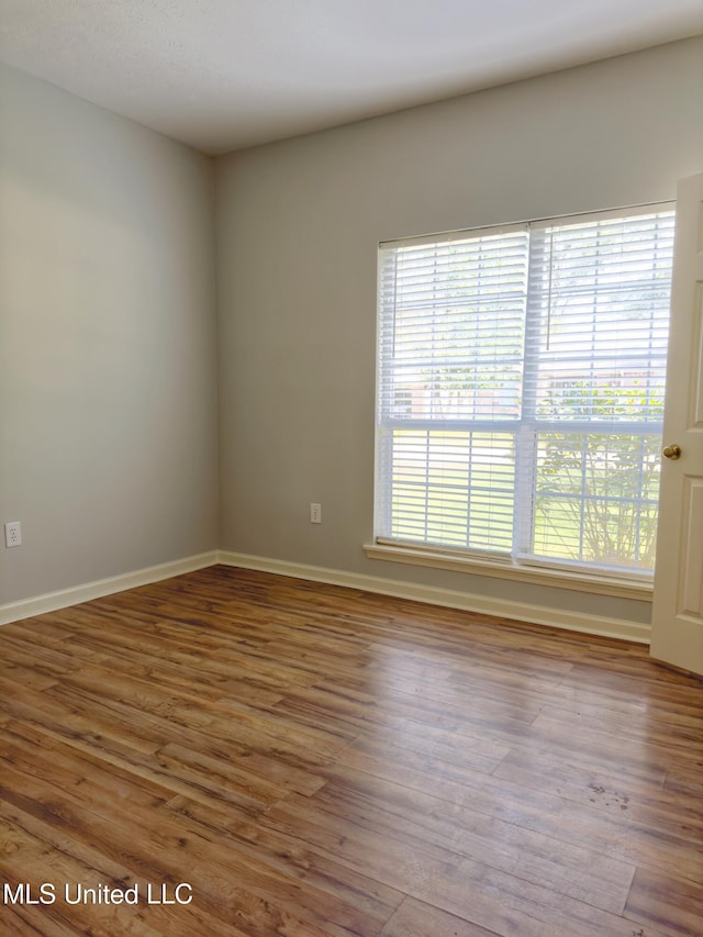 unfurnished room featuring hardwood / wood-style floors and plenty of natural light