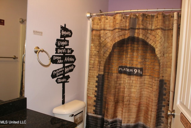 bathroom featuring a shower with curtain, vanity, and toilet