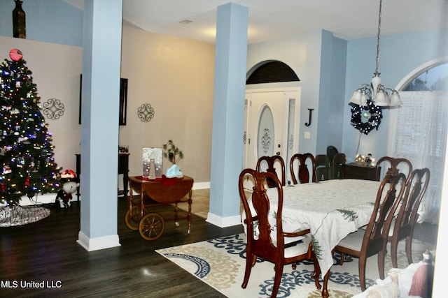 dining area with dark hardwood / wood-style flooring and a notable chandelier