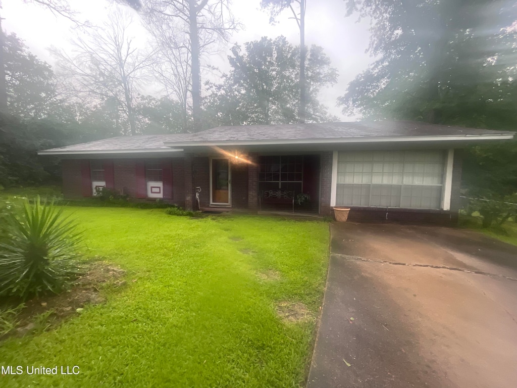 view of front of home with a front yard and a garage