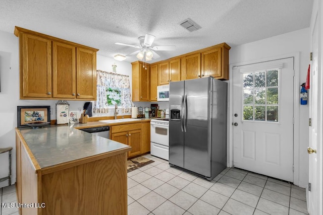 99102 Koloa St, Diamondhead, MS 39525 - kitchen featuring stainless steel appliances, a peninsula, ceiling fan, brown cabinetry, and a textured ceiling