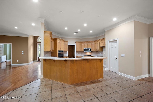 kitchen featuring oven, light hardwood / wood-style flooring, kitchen peninsula, backsplash, and crown molding