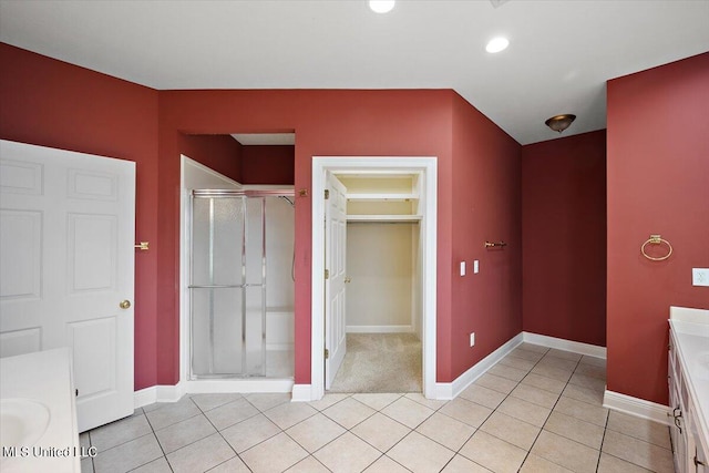 bathroom featuring a shower with door, vanity, and tile patterned flooring