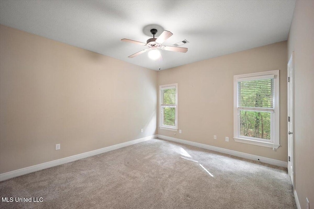 carpeted empty room featuring a textured ceiling and ceiling fan