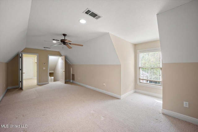 additional living space featuring lofted ceiling, light colored carpet, and ceiling fan