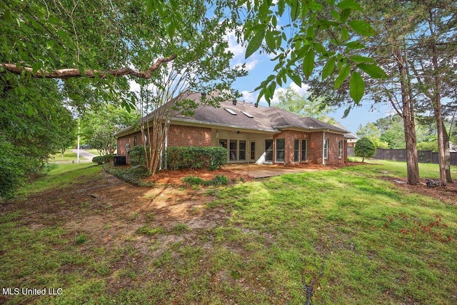 back of house with fence, a yard, french doors, and brick siding