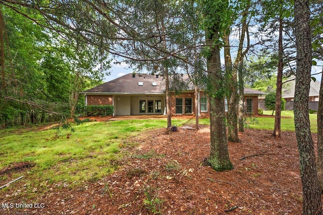 rear view of property with a yard