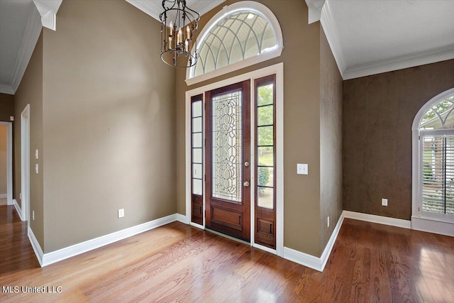 foyer featuring a notable chandelier, crown molding, and hardwood / wood-style flooring