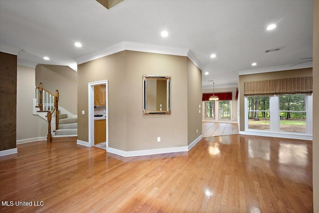 spare room with light hardwood / wood-style floors and crown molding