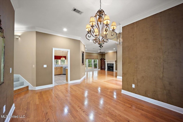 unfurnished dining area featuring visible vents, an inviting chandelier, ornamental molding, recessed lighting, and light wood-style flooring