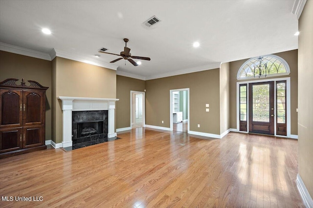 unfurnished living room with light hardwood / wood-style flooring, ornamental molding, ceiling fan, and a high end fireplace