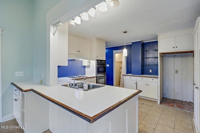 223 Hannah Dr, Clinton, MS 39056 - kitchen featuring a sink, white cabinets, a peninsula, light countertops, and under cabinet range hood