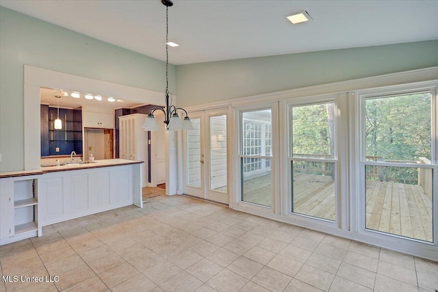 223 Hannah Dr, Clinton, MS 39056 - kitchen featuring vaulted ceiling, a sink, light countertops, white cabinetry, and pendant lighting