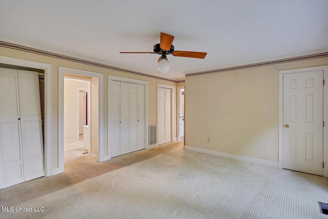 223 Hannah Dr, Clinton, MS 39056 - unfurnished bedroom featuring two closets, light colored carpet, baseboards, crown molding, and ceiling fan