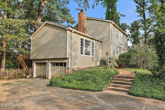 223 Hannah Dr, Clinton, MS 39056 - view of side of property featuring a chimney, an attached garage, stairway, and driveway