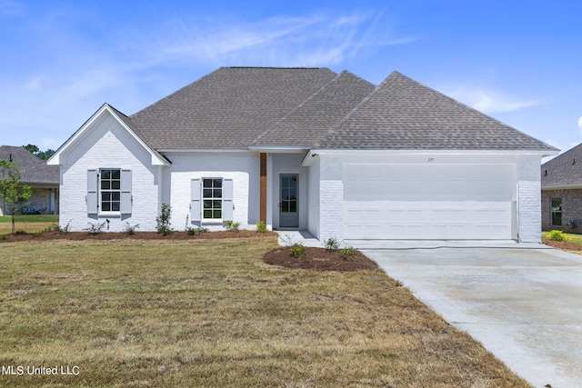 view of front of property with a front lawn and a garage