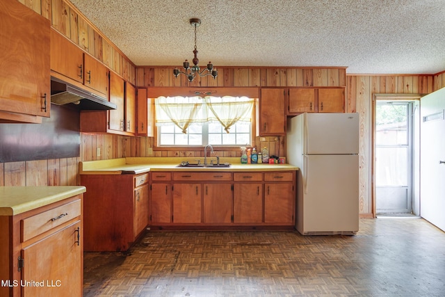 512 Saint Paul Ave, Senatobia, MS 38668 - kitchen featuring freestanding refrigerator, under cabinet range hood, wood walls, a chandelier, and plenty of natural light
