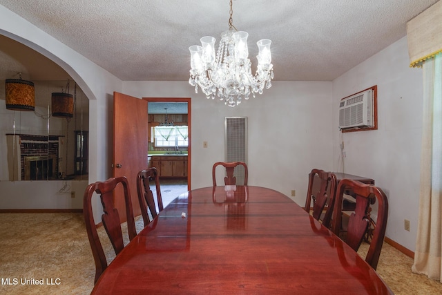 512 Saint Paul Ave, Senatobia, MS 38668 - carpeted dining area with a heating unit, arched walkways, a chandelier, a textured ceiling, and a wall mounted AC