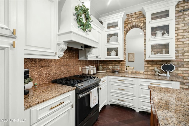 kitchen with white cabinets, gas stove, light stone counters, and premium range hood