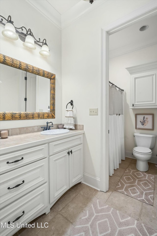 bathroom with tile patterned flooring, vanity, toilet, and crown molding