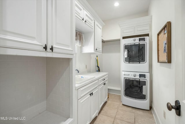 laundry area with cabinets, sink, and stacked washing maching and dryer