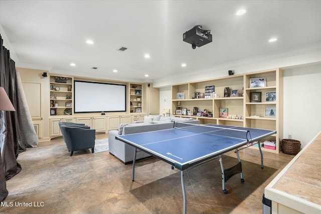 game room with built in shelves and ornamental molding