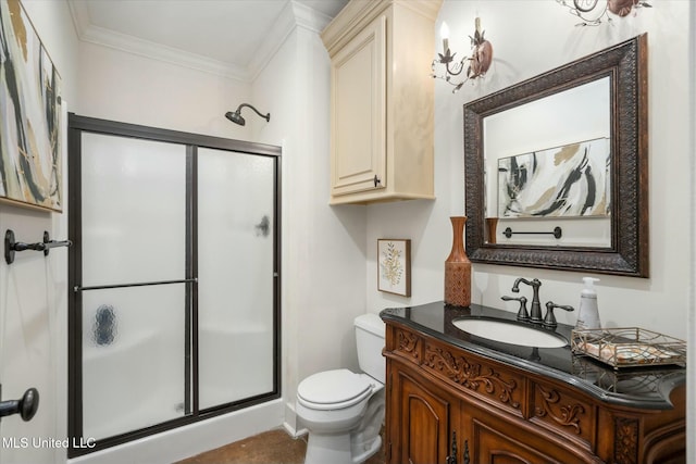 bathroom featuring vanity, toilet, a shower with door, and crown molding