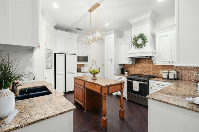 kitchen with pendant lighting, white cabinets, stainless steel appliances, and dark hardwood / wood-style floors