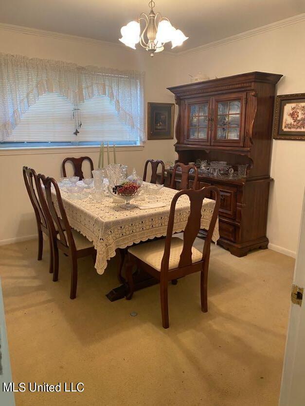 22 N Joliffe St, Eupora, MS 39744 - dining room featuring baseboards, an inviting chandelier, light carpet, and ornamental molding