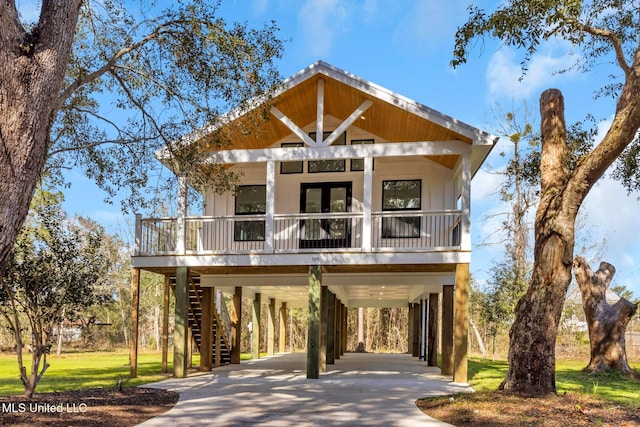 coastal home with a carport, stairs, and concrete driveway