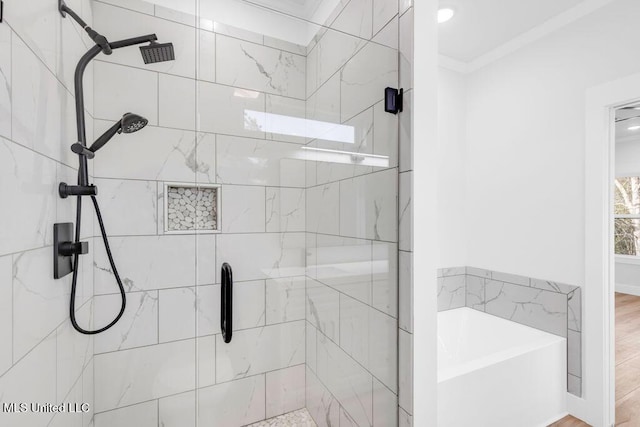 bathroom with a garden tub, a shower stall, ornamental molding, and wood finished floors