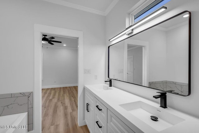 full bathroom with double vanity, crown molding, a sink, and wood finished floors