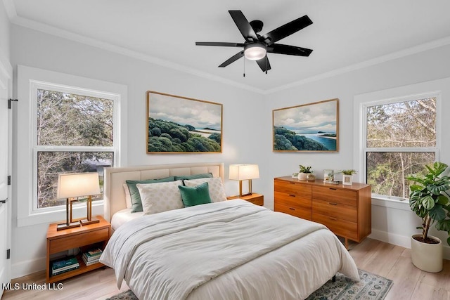 bedroom featuring ornamental molding, multiple windows, and light wood-type flooring