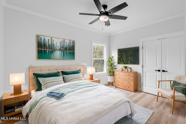 bedroom featuring light wood-style floors, ceiling fan, ornamental molding, and a closet