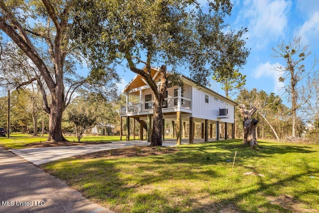 view of side of home with a carport, a lawn, and concrete driveway