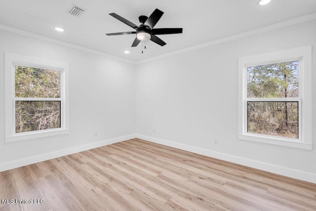 spare room featuring a healthy amount of sunlight, baseboards, and ornamental molding