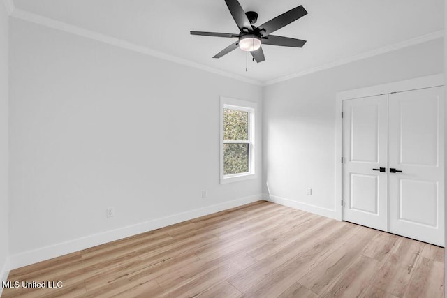 unfurnished bedroom featuring a closet, ornamental molding, light wood-style floors, a ceiling fan, and baseboards