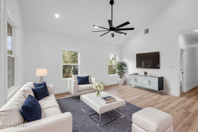 living area with baseboards, visible vents, and wood finished floors