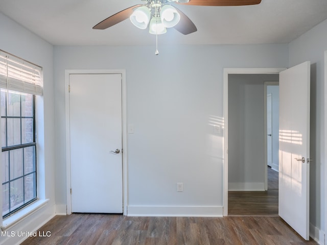 unfurnished room featuring dark wood-type flooring and ceiling fan