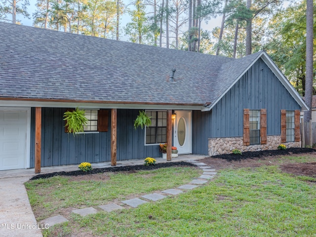 view of front of home featuring a front lawn, covered porch, and a garage