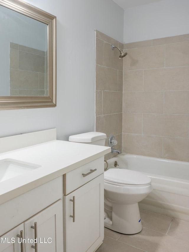 full bathroom featuring toilet, tiled shower / bath, vanity, and tile patterned flooring