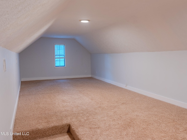 bonus room featuring a textured ceiling, carpet, and vaulted ceiling