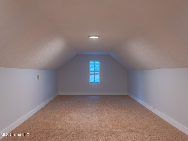 additional living space with lofted ceiling and carpet flooring