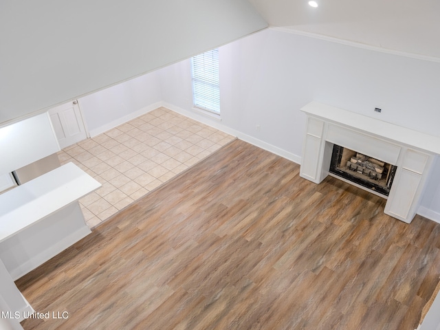 additional living space featuring light hardwood / wood-style flooring and lofted ceiling